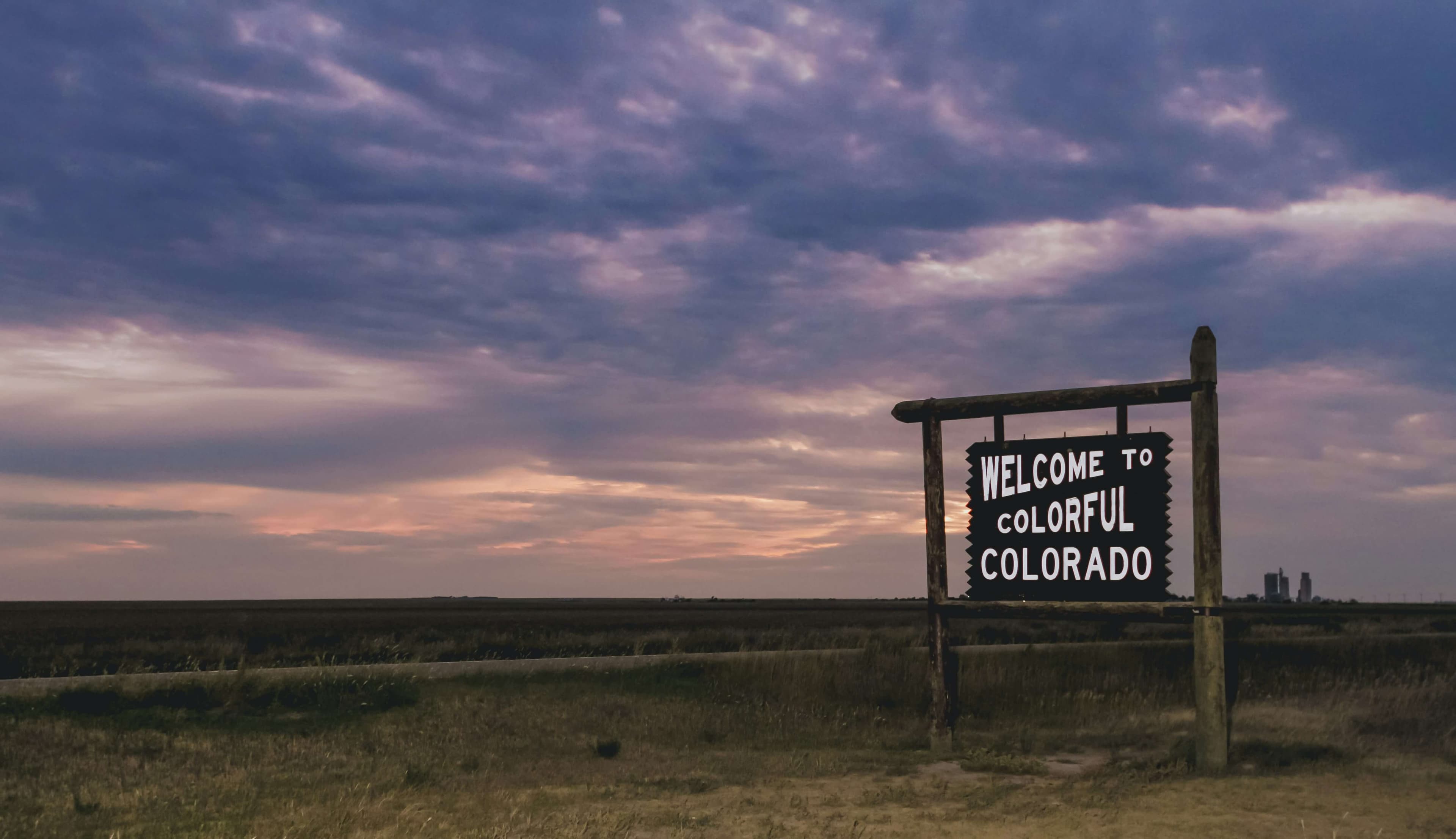 Welcome to Colorful Colorado sign standing on the eastern plains at dusk, near the heart of DJ Basin country.